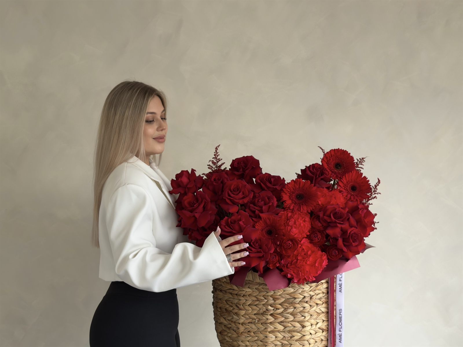 Âme Flowers founder with a red rose arrangement